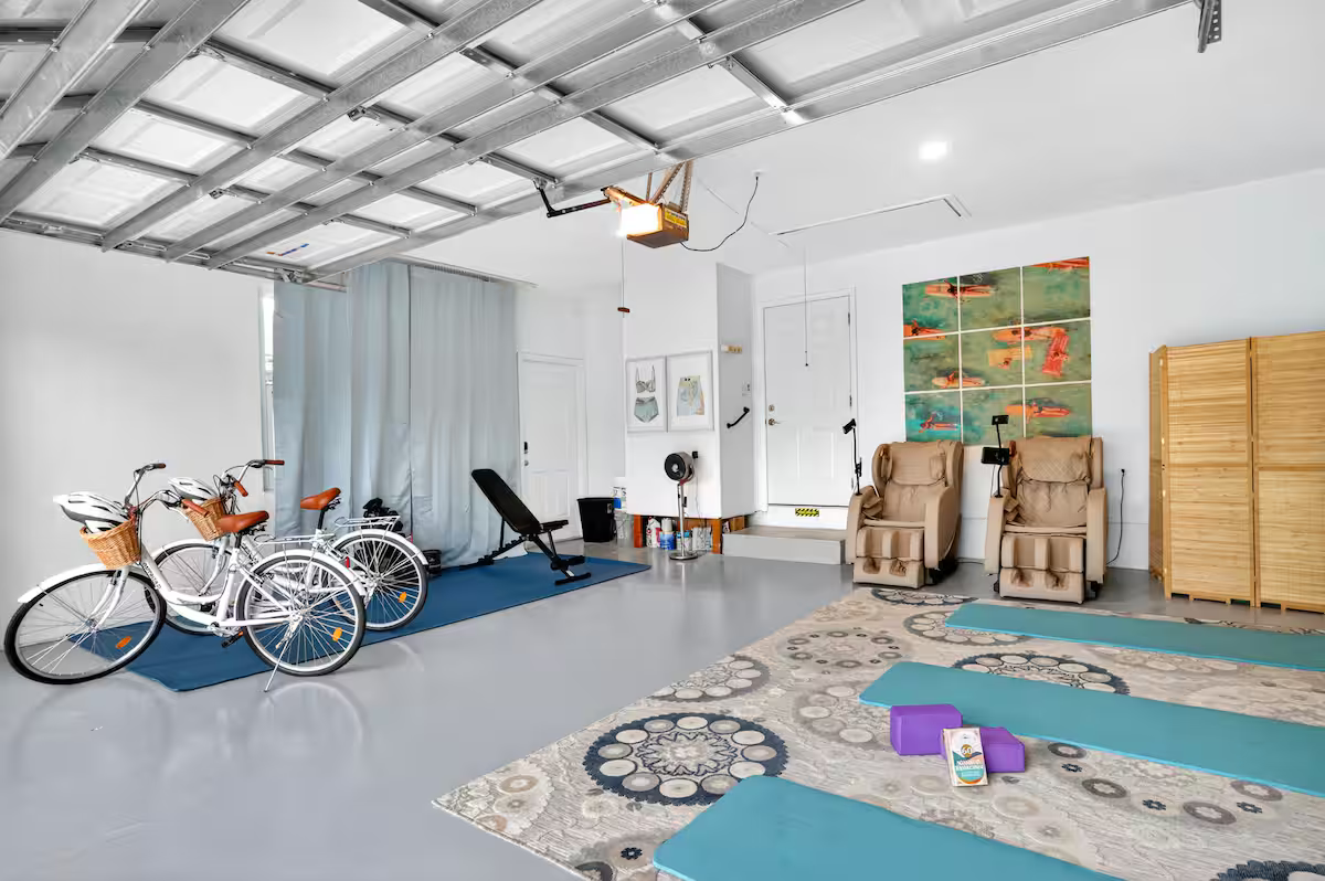 Garage game area with bikes, massage chairs, and yoga space