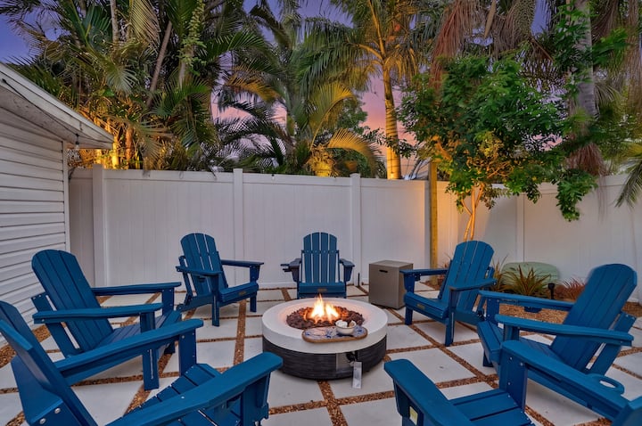 Backyard fire pit with Adirondack chairs at dusk